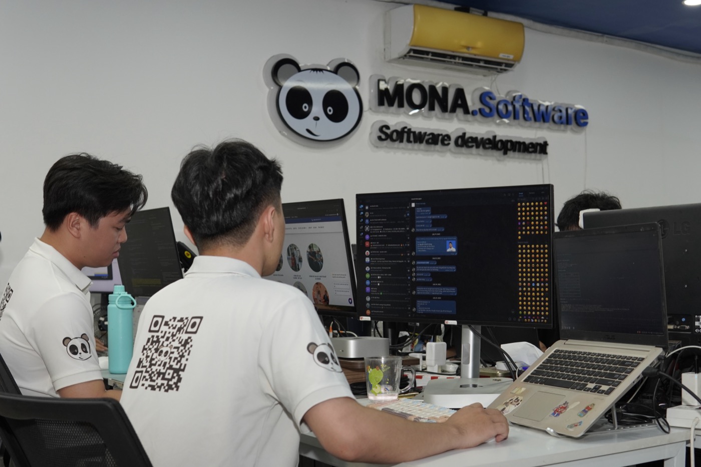Nhân viên MONA làm việc, biển nhận diện MONA.Software phía sau